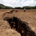 Women work on their farm near a chasm suspected to have been caused by a heavy downpour along an underground fault-line near the Rift Valley town of Mai Mahiu, Kenya March 28, 2018. REUTERS/Thomas Mukoya
